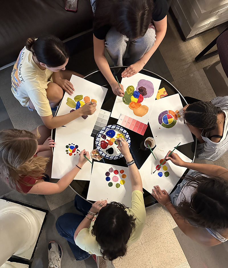 Picture taken from overhead of a group of Monacan Humanities students painting